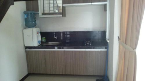 uma pequena cozinha com um lavatório e um frigorífico em Resort Faza em Garut
