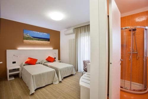 a hotel room with two beds and a shower at La Casa del Turista in Gallipoli