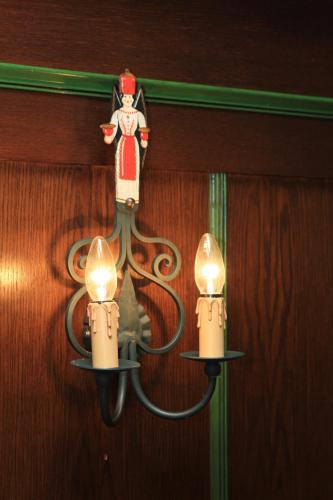 a light hanging on a wall with two candles at Hotel Erbgericht Buntes Haus in Seiffen