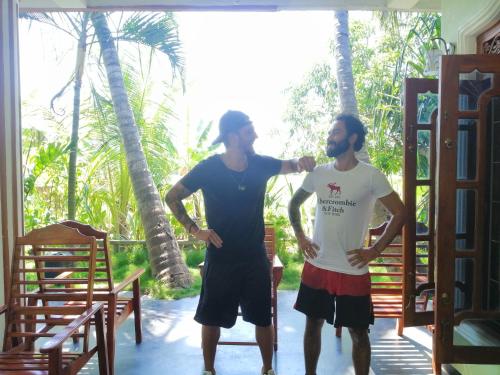 two men standing next to each other in a room at Viveka Inn Guest and Yala Safari in Tissamaharama