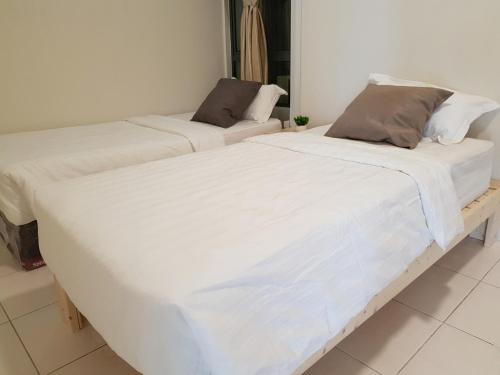 two beds sitting next to each other in a room at S3 The Wood @ The Best Location at Puchong in Puchong