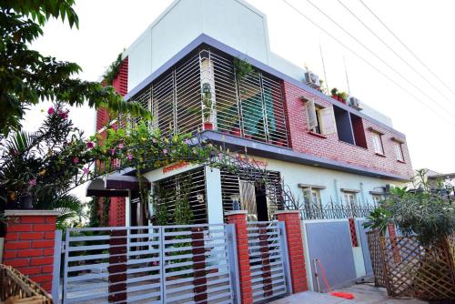 ein Haus mit einem weißen Zaun davor in der Unterkunft Mango Tree Homestay in Hampi