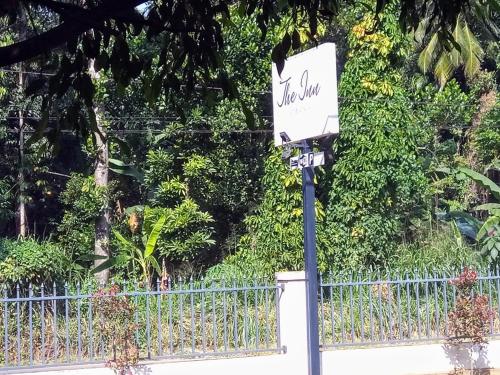 a sign on a pole in front of a fence at The Inn At Matale in Matale