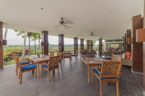 a restaurant with wooden tables and chairs and windows at The Samaya Ubud in Ubud
