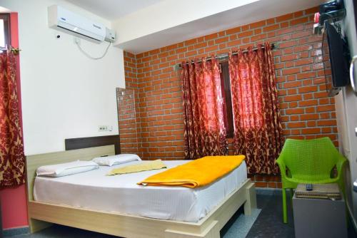 a bedroom with a bed and a brick wall at Mango Tree Homestay in Hampi