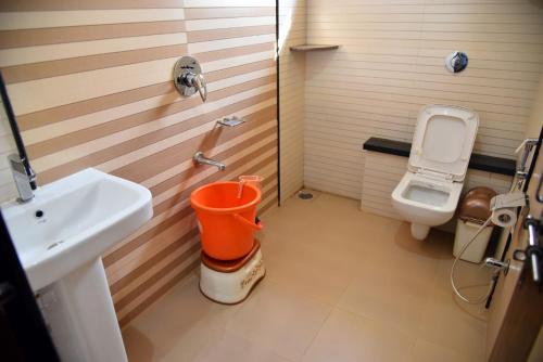 a bathroom with a sink and a toilet at Mango Tree Homestay in Hampi