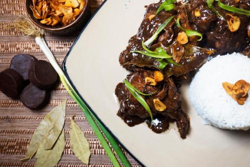 a plate of food with beef and rice and a bowl of food at Balai Princesa in Puerto Princesa City