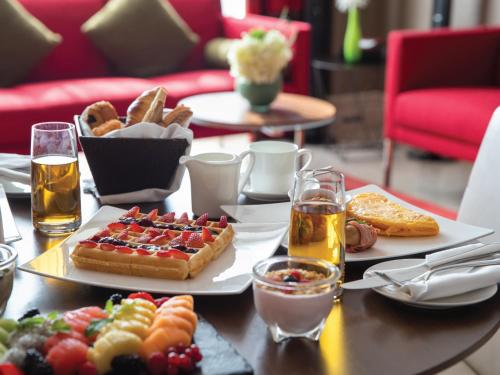 a table topped with plates of food and drinks at Creekside Hotel in Dubai