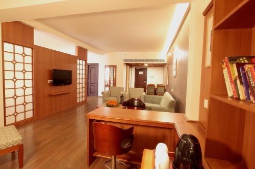 a living room with a couch and a table at Monsoon Empress Kochi in Cochin