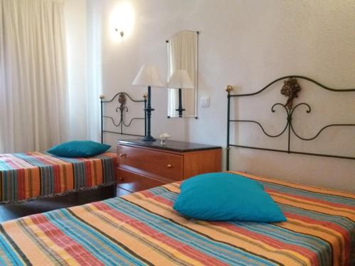 een hotelkamer met 2 bedden en een spiegel bij Casa 61C -1º - Monte Fino - Monte Gordo in Vila Real de Santo António