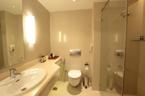 a bathroom with a sink and a toilet and a shower at Monsoon Empress Kochi in Cochin