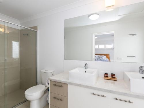 a white bathroom with a toilet and a sink at Torquay Timeout in Torquay