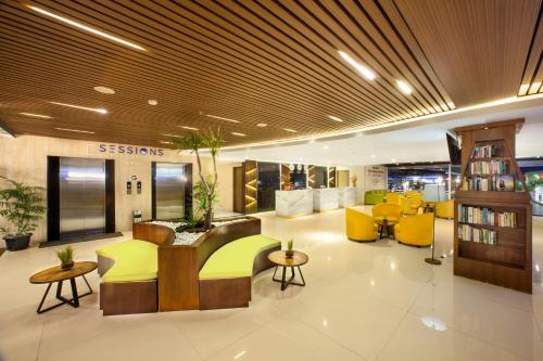 a lobby with a library with yellow chairs and tables at New Garden View Resort - CHSE Certified in Legian