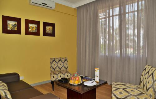a living room with a couch and a table and chairs at Cresta Oasis Hotel in Harare