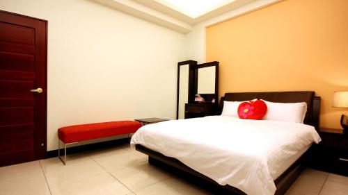 ein Schlafzimmer mit einem Bett mit einem roten Kissen darauf in der Unterkunft Summer House in Altstadt von Hengchun