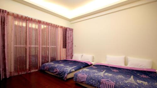 1 Schlafzimmer mit 2 Betten und einem Fenster in der Unterkunft Summer House in Altstadt von Hengchun