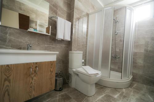 een badkamer met een toilet, een wastafel en een douche bij Grand Dost Hotel in Osmancık
