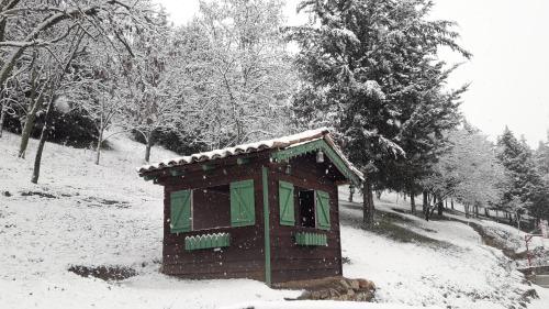 a small building in the snow with trees in the background at Traditional Guesthouse in Tríkala