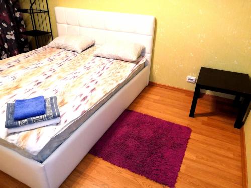 uma cama com duas almofadas e um tapete num quarto em 3-комнатная квартира для БОЛЬШОЙ СЕМЬИ или ТИХОЙ КОМПАНИИ em Vladimir