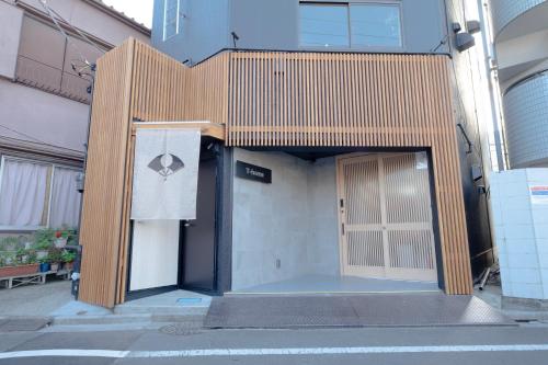 a wooden building with a door on the side of a building at T-home 2 in Tokyo