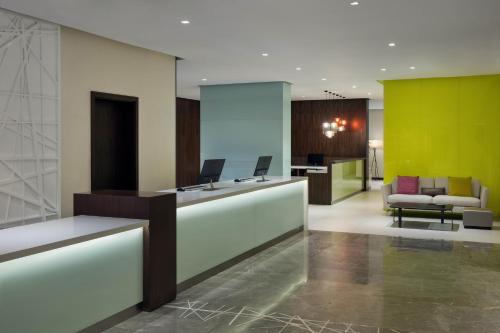 an office lobby with a reception desk and chairs at Hyatt House Jeddah Sari Street in Jeddah