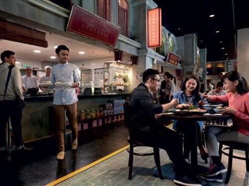a group of people sitting at a table in a restaurant at Resorts World Genting - First World Hotel in Genting Highlands