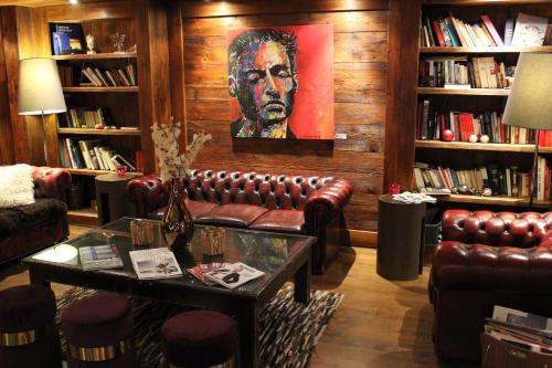 a living room with a leather couch and a painting at Hotel Tsanteleina in Val dʼIsère