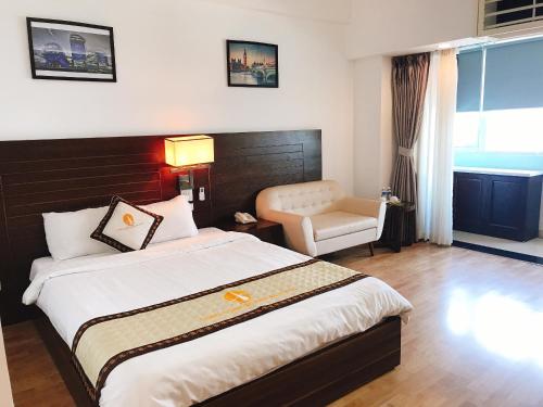 a hotel room with a large bed and a chair at Khách sạn Công Đoàn Quảng Bá in Hanoi