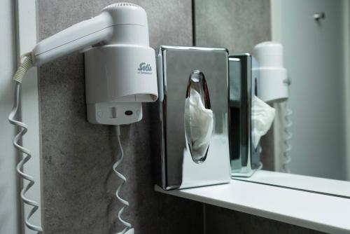 a bathroom with a hair dryer and a mirror at Hotel Waldhorn in Bern