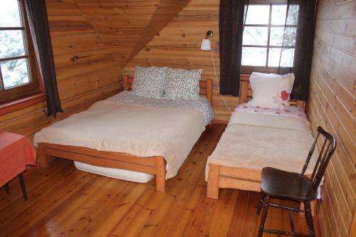 a bedroom with two beds in a log cabin at Aido ir Vido sodyba in Utena