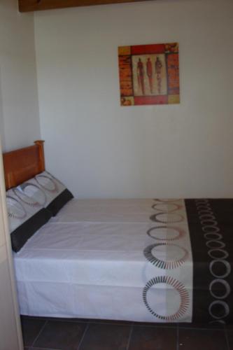 a bedroom with a bed with a blanket on it at Hibberdene Hideout in Hibberdene