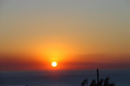 a sunset over the ocean with the sun in the sky at Hibberdene Hideout in Hibberdene