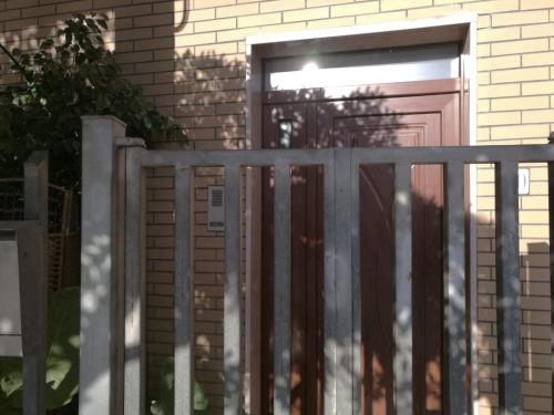 a wooden gate in front of a house with a door at Casa Etimo in Manduria