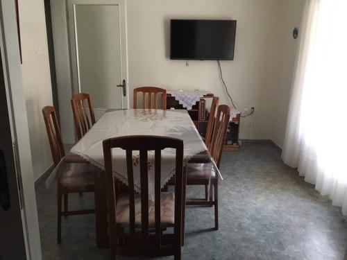 a dining room with a table with chairs and a television at 30 Amynta in Katerini