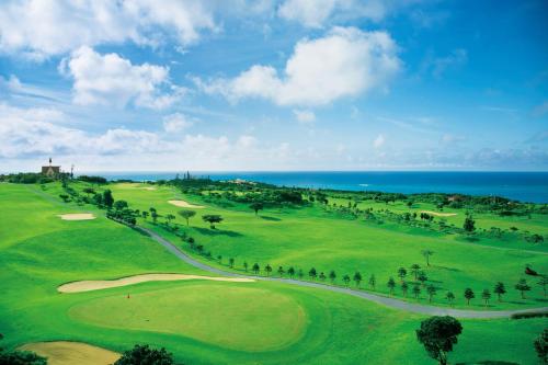 a view of a golf course with the ocean in the background at The Shigira in Miyako Island