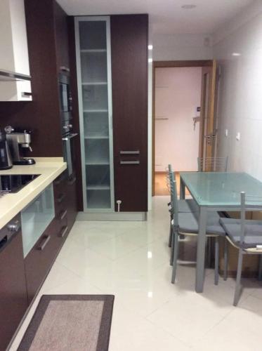 a kitchen with a table and chairs in a kitchen at ADALBERTO NASCIMENTO LUXURY APARTA-HOSTEL At COLINAS DO CRUZEIRO in Odivelas