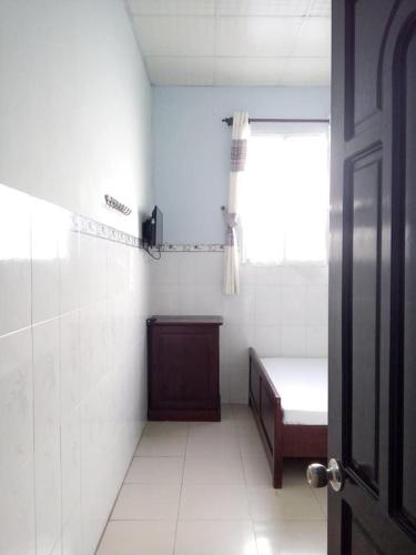 a room with a bed and a window and a door at Minh Duc Guesthouse in Phan Thiet