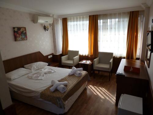 une chambre d'hôtel avec un lit et des serviettes. dans l'établissement Istanbul Yildiz Hotel, à Marmaraereglisi