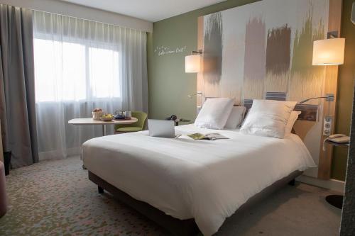 Ένα ή περισσότερα κρεβάτια σε δωμάτιο στο Mercure Reims Parc Des Expositions