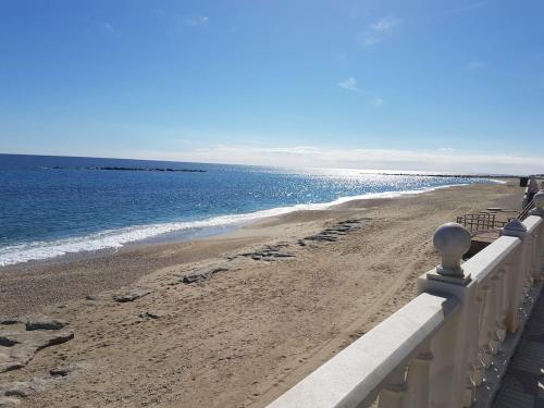 a beach with a white fence and the ocean at Casa Nimajas in Vera