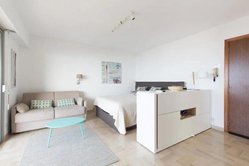 a bedroom with a bed and a couch and a table at Bijou Plage in Juan-les-Pins