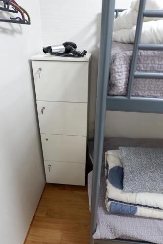 a white dresser next to a bunk bed at Haru The Guesthouse in Andong