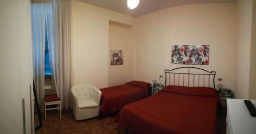 1 dormitorio con 2 camas, silla y ventana en Hotel Universo, en Fiuggi