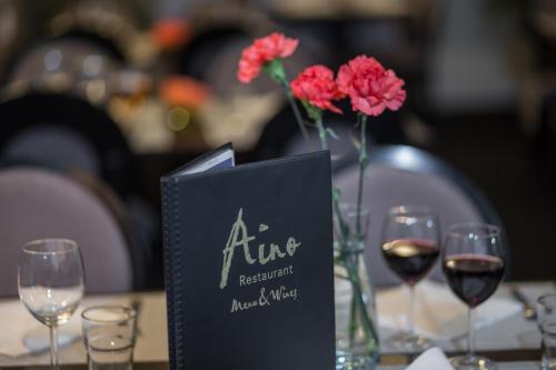 a table topped with glasses of wine and flowers at Park Hotel Tornio in Tornio