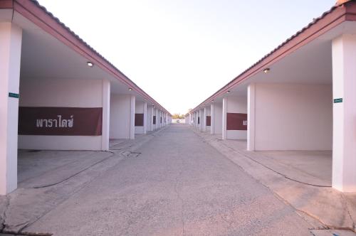 an empty hallway of a building with white walls at Paradise Inn and Dining in Sara Buri