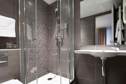 a bathroom with a shower and a sink at Hôtel Eiffel Saint Charles in Paris