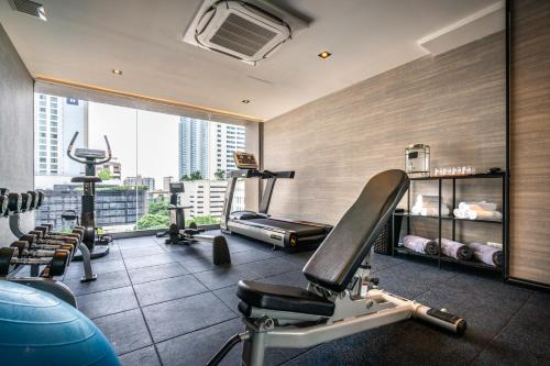 a gym with cardio equipment and a large window at Tastoria Collection Sukhumvit in Bangkok