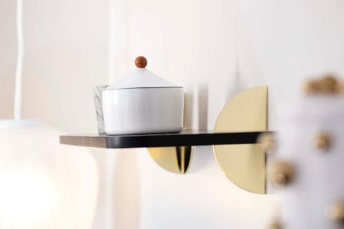 a black and gold shelf with a tea kettle on it at Hôtel Eiffel Saint Charles in Paris