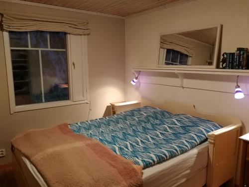 1 dormitorio con cama y espejo en Villa Rauha, en Kittilä