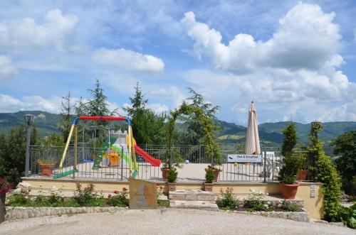 a playground with a slide and an umbrella at B&B La Terrazza Del Subasio in Assisi